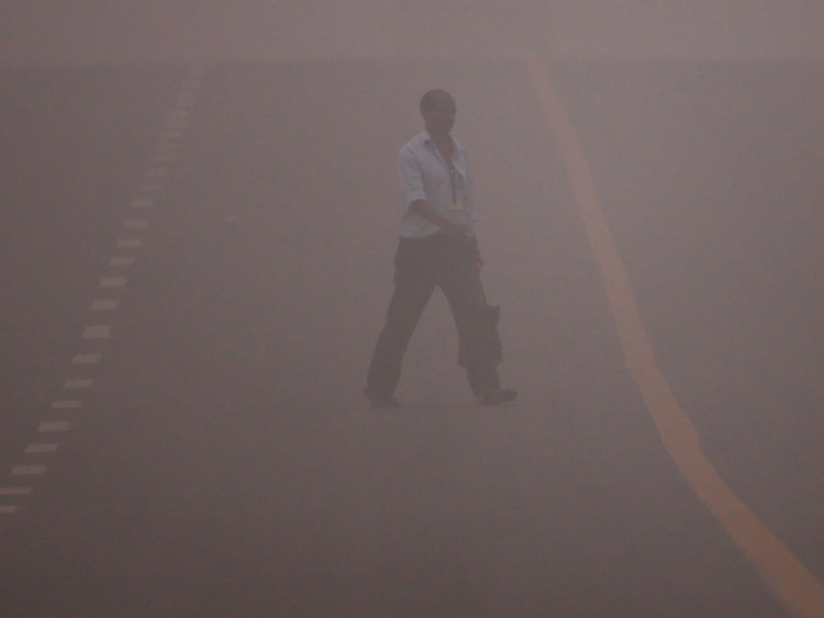 A man crosses a road amidst the heavy smog in New Delhi, India, November 6, 2016. REUTERS/Adnan Abidi     TPX IMAGES OF THE DAY      - RTX2S5FF